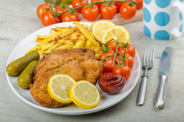 Big Chicken schnitzel with homemade chilli french fries Stock photo © Peteer