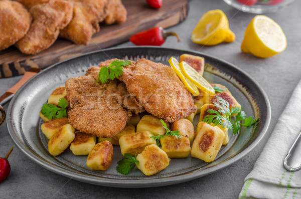 Schnitzel original with lemon and gnocchi fried Stock photo © Peteer