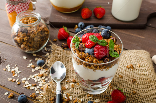 Yogurt with baked granola and berries in small glass Stock photo © Peteer