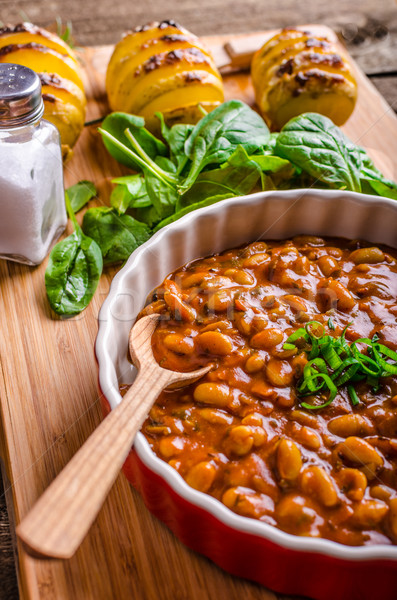 Spicy cowboy beans with hassleback potatoe with herbs Stock photo © Peteer