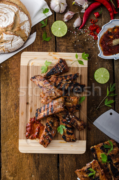 Grilled Spareribs in spicy marinade with beer and rustic bread Stock photo © Peteer