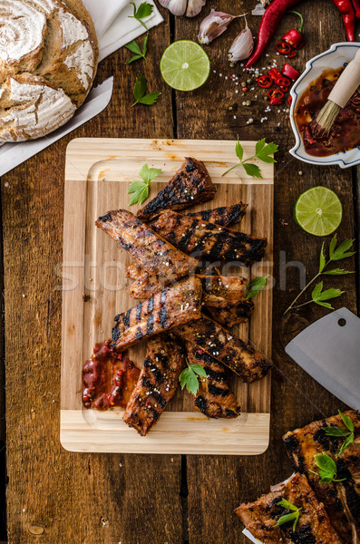 Grilled Spareribs in spicy marinade with beer and rustic bread Stock photo © Peteer