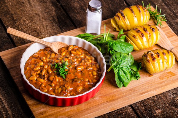 Spicy cowboy beans with hassleback potatoe with herbs Stock photo © Peteer