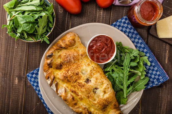 Stock photo: Calzone pizza stuffed with cheese and prosciutto