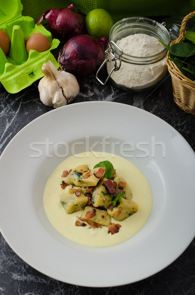 Spinach gnocchi with parmesan sauce topped with bacon Stock photo © Peteer