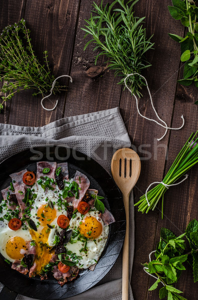 Sült tojások sonka gyógynövények mini paradicsomok Stock fotó © Peteer