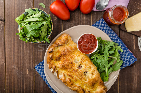 Stock photo: Calzone pizza stuffed with cheese and prosciutto