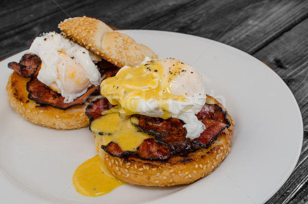 Benedict eggs with crispy bacon and hollandaise sauce on toasted Maffin Stock photo © Peteer