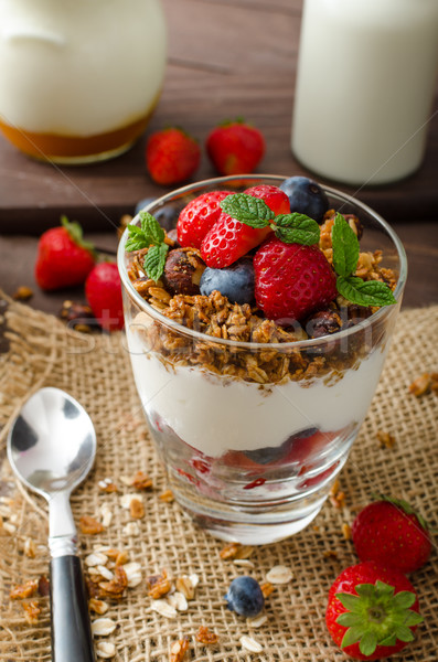 Yogurt with baked granola and berries in small glass Stock photo © Peteer