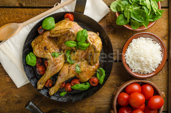 Stock photo: Chicken baked with tomatoes and basil on iron pan