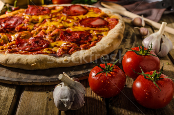 Rustic salami pizza with cheddar cheese and chorizo Stock photo © Peteer