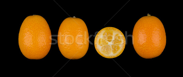 Stock photo: Four Oval Kumquats In A Row On Black Background