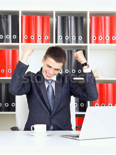 Fiatal üzletember diadal néz laptop üzlet Stock fotó © PetrMalyshev