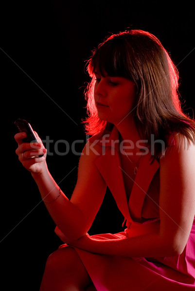 Ragazza chiamata cellulare buio luce rossa donna Foto d'archivio © PetrMalyshev