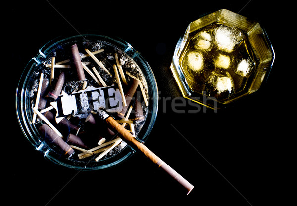 ashtray full of butts and glass of whiskey Stock photo © PetrMalyshev