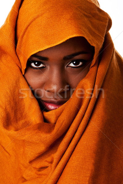 Mysterious female face in ocher head wrap Stock photo © phakimata