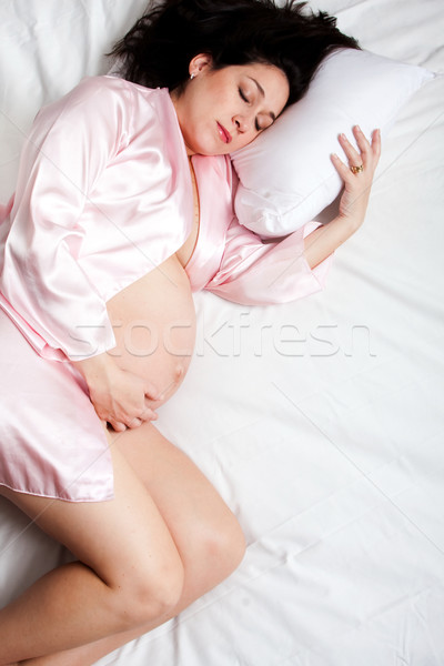 Sleeping pregnant woman in bed Stock photo © phakimata