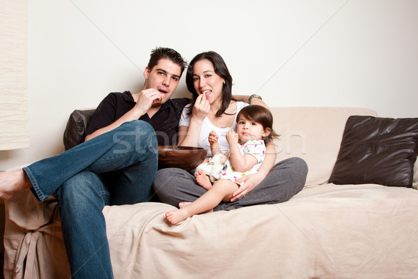 Happy family snacking on sofa couch Stock photo © phakimata