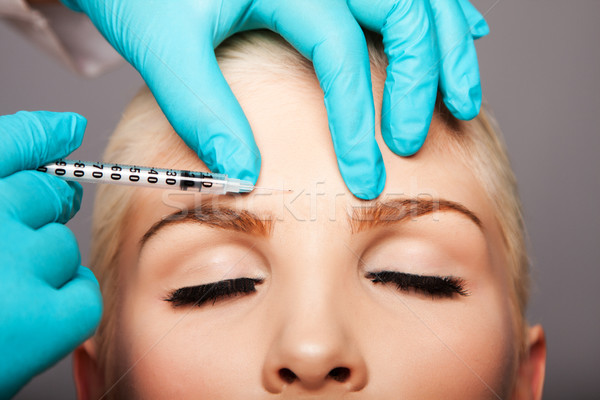 Cosmetic plastic surgeon injecting aesthetics face Stock photo © phakimata