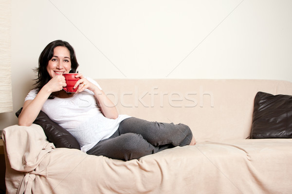 Woman with drink on couch Stock photo © phakimata