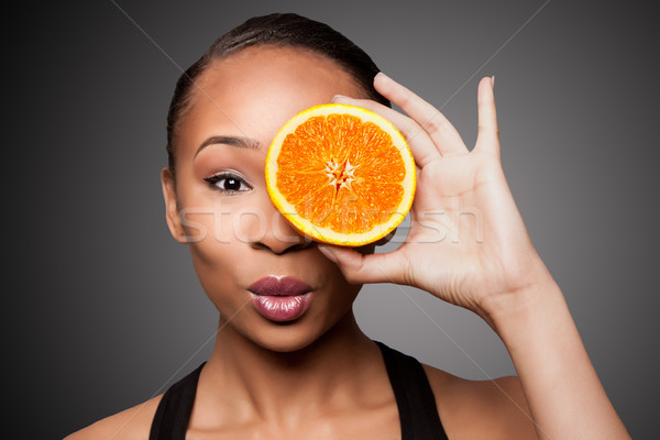 Happy healthy black asian woman with orange fruit Stock photo © phakimata