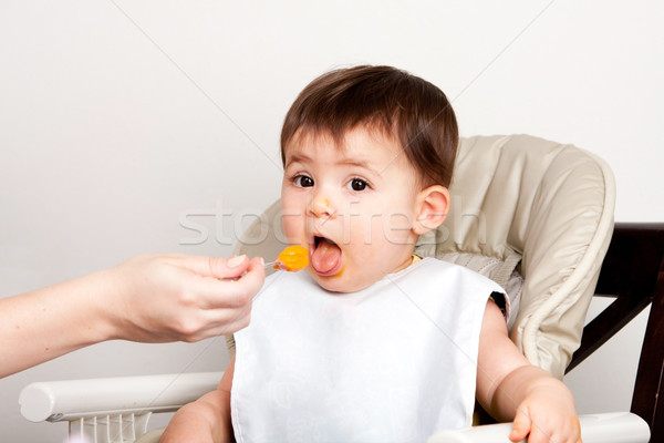 Happy baby spoon feeding Stock photo © phakimata