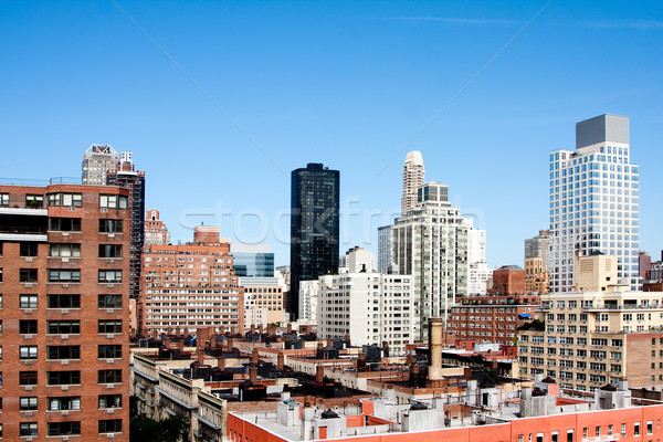 Building rooftops under blue sky Stock photo © phakimata