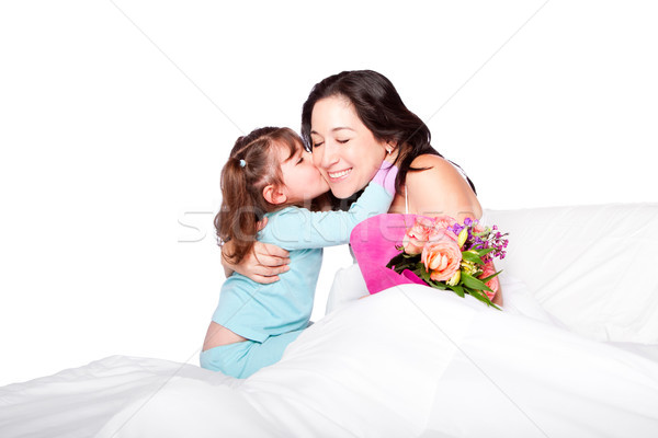 Child gives flowers and kiss to mom in bed Stock photo © phakimata