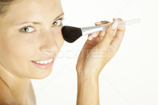 portrait of young woman putting on face powder Stock photo © phbcz
