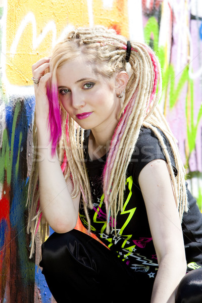 portrait of young woman sitting at graffitti wall Stock photo © phbcz