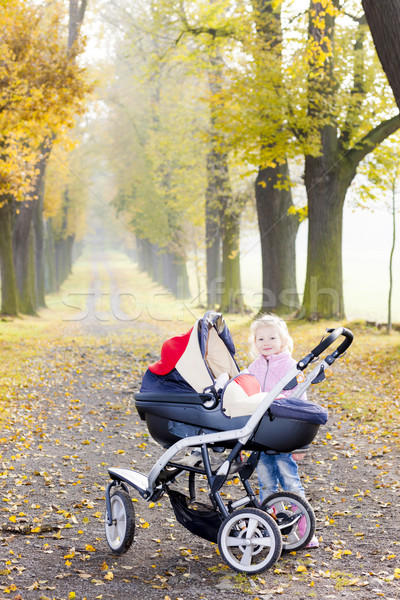 little girl with a pram on walk in autumnal alley Stock photo © phbcz