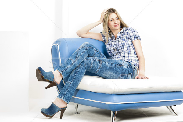 Frau Sitzung Sofa tragen Jeans Denim Stock foto © phbcz