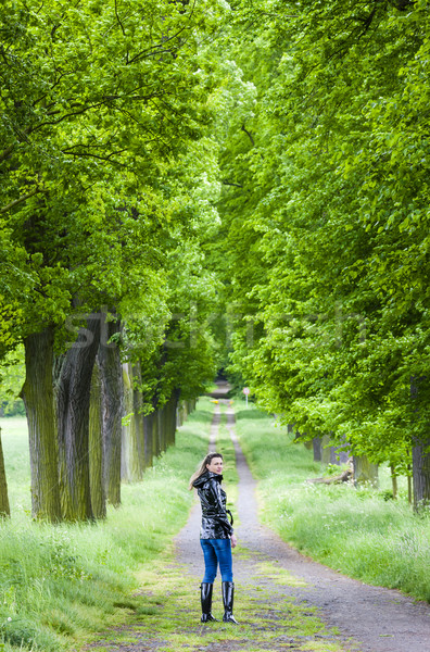 woman wearing rubber boots walking in spring alley Stock photo © phbcz