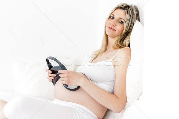 Foto stock: Mulher · grávida · fones · de · ouvido · cama · mulher · grávida