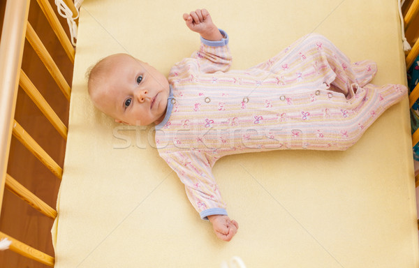 lying two month old baby girl in cot Stock photo © phbcz
