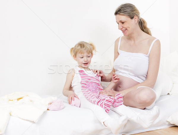 little girl and her pregnant mother with clothes for a baby Stock photo © phbcz