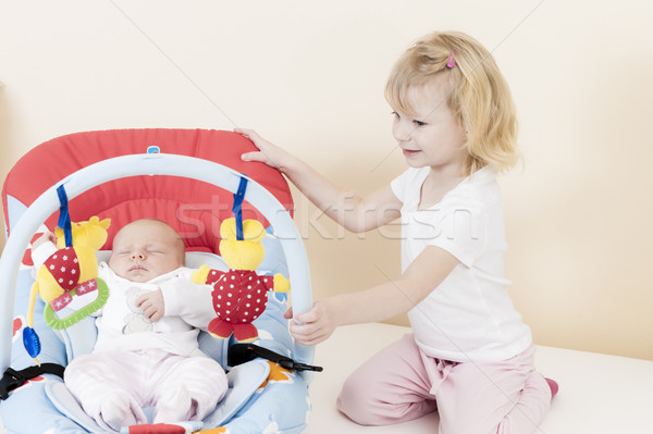 portrait of a little girl with her baby sister sleeping in a cha Stock photo © phbcz