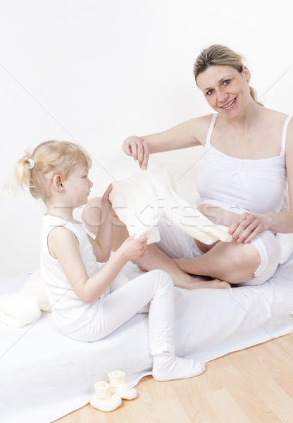 little girl and her pregnant mother with clothes for a baby Stock photo © phbcz