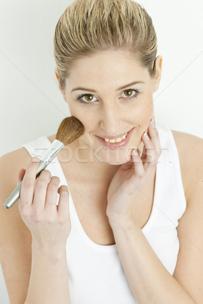 portrait of young woman putting on face powder Stock photo © phbcz