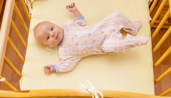 lying two month old baby girl in cot Stock photo © phbcz