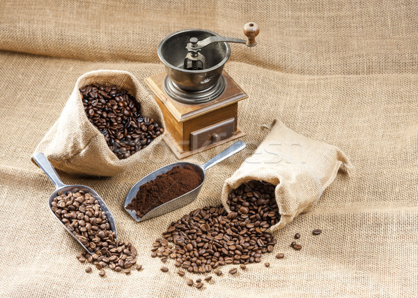 still life of coffee beans in jute bags with coffee grinder Stock photo © phbcz