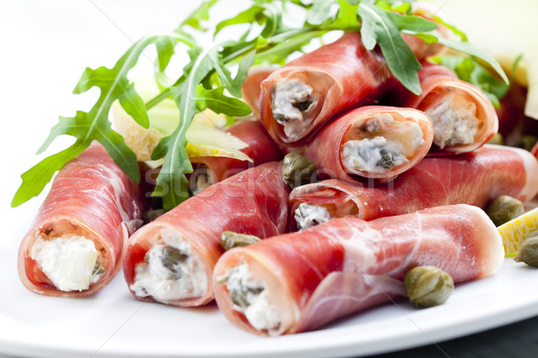Parma ham rolls filled with cream cheese, Galia melon and capers Stock photo © phbcz
