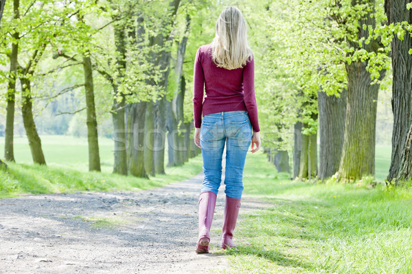 woman wearing rubber boots walking in spring alley Stock photo © phbcz