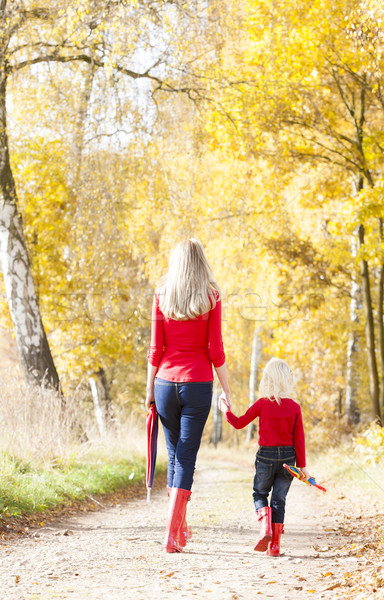 mother with her daughter with umbrellas in autumnal alley Stock photo © phbcz