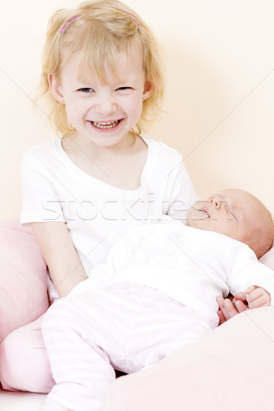 portrait of a little girl cradling her one month old baby sister Stock photo © phbcz