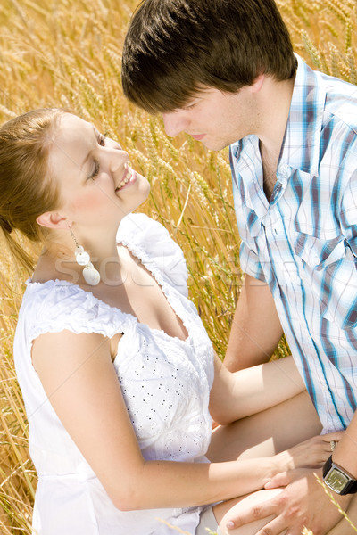 young couple sitting in grain field Stock photo © phbcz