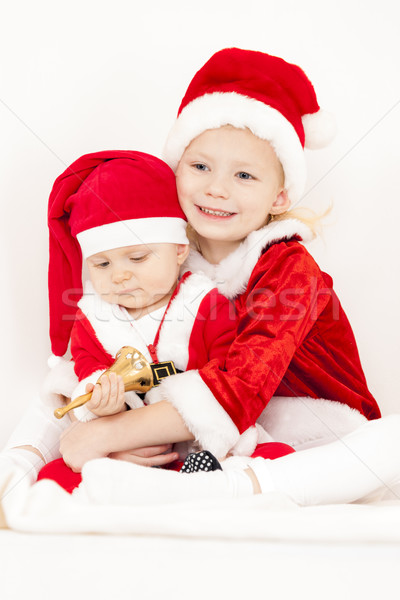 two little girls as Santa Clauses with a bell Stock photo © phbcz