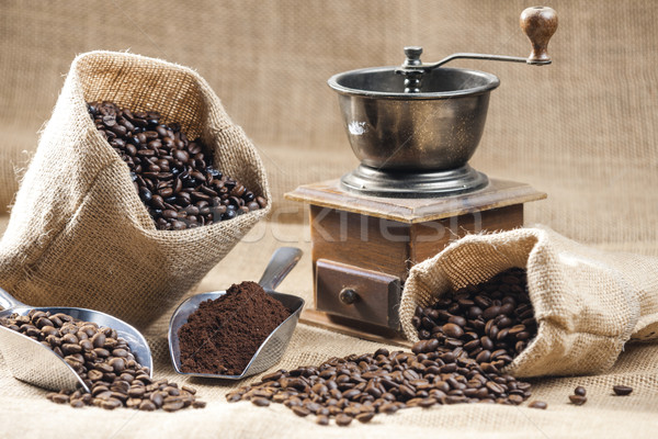 still life of coffee beans in jute bags with coffee grinder Stock photo © phbcz