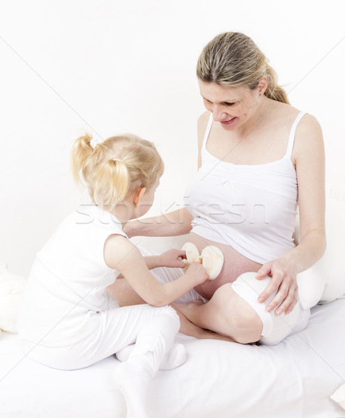 little girl and her pregnant mother with shoes for a baby Stock photo © phbcz