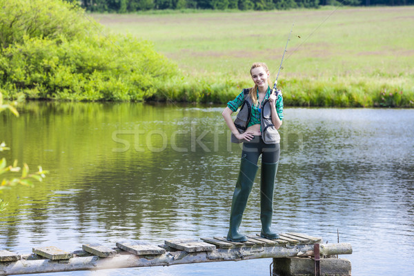 Stock photo: young woman fishing on pier at pond